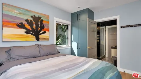 a bedroom with a bed and a painting on the wall