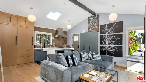 a living room with furniture a chandelier and a large mirror