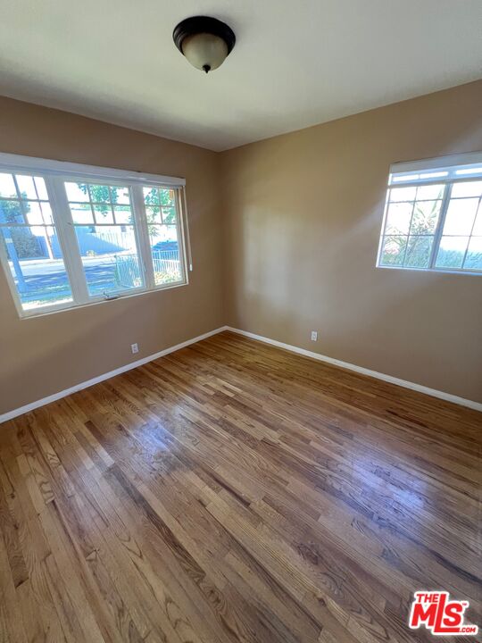 17844 Hartland Street Reseda, CA 91335 - Photo 10 of 18 an empty room with wooden floor and windows