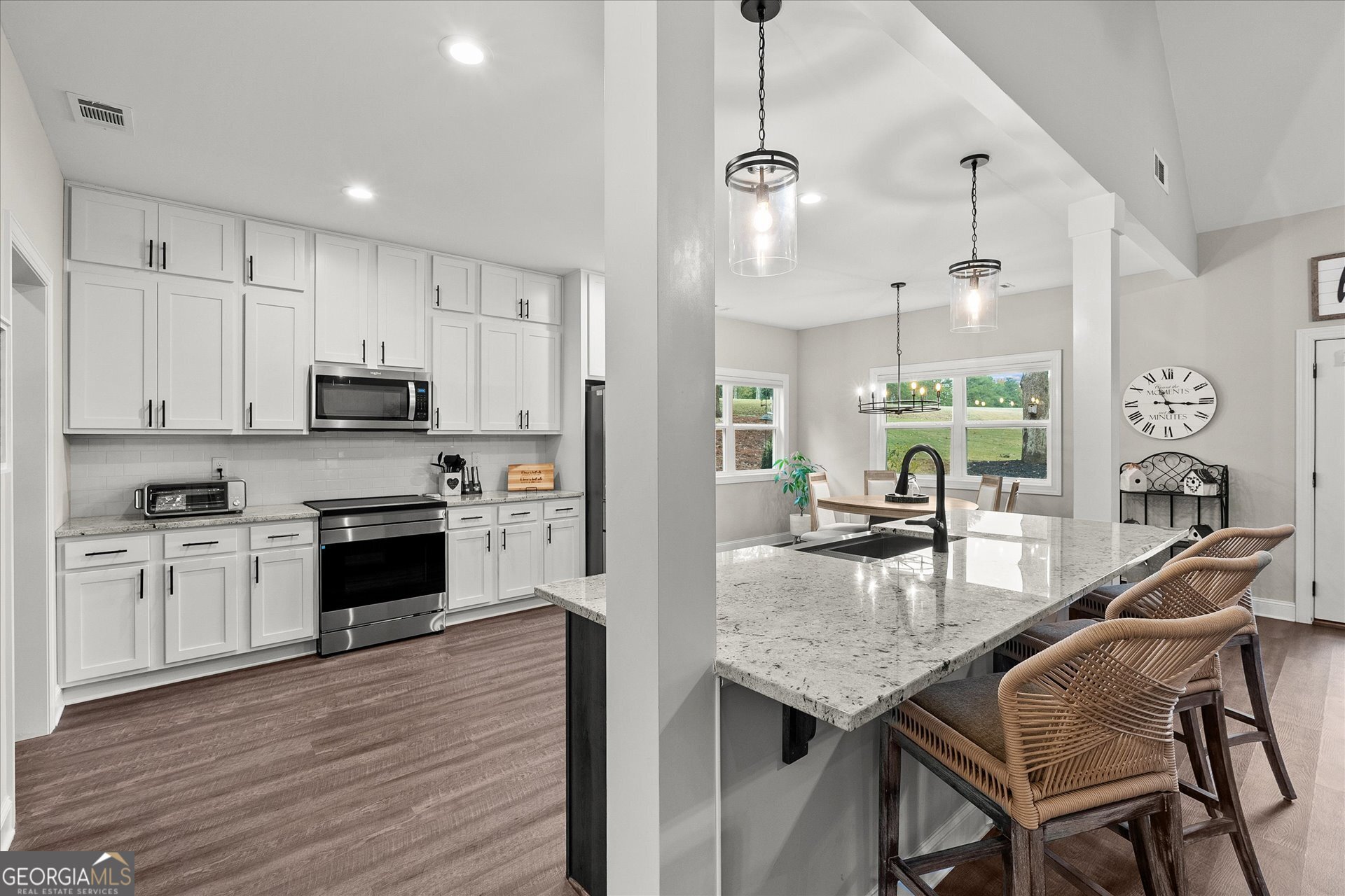 3260 Greenhill Court Villa Rica, GA 30180 - Photo 20 of 80 a kitchen with stainless steel appliances granite countertop a stove top oven a refrigerator a sink and chairs with wooden floor