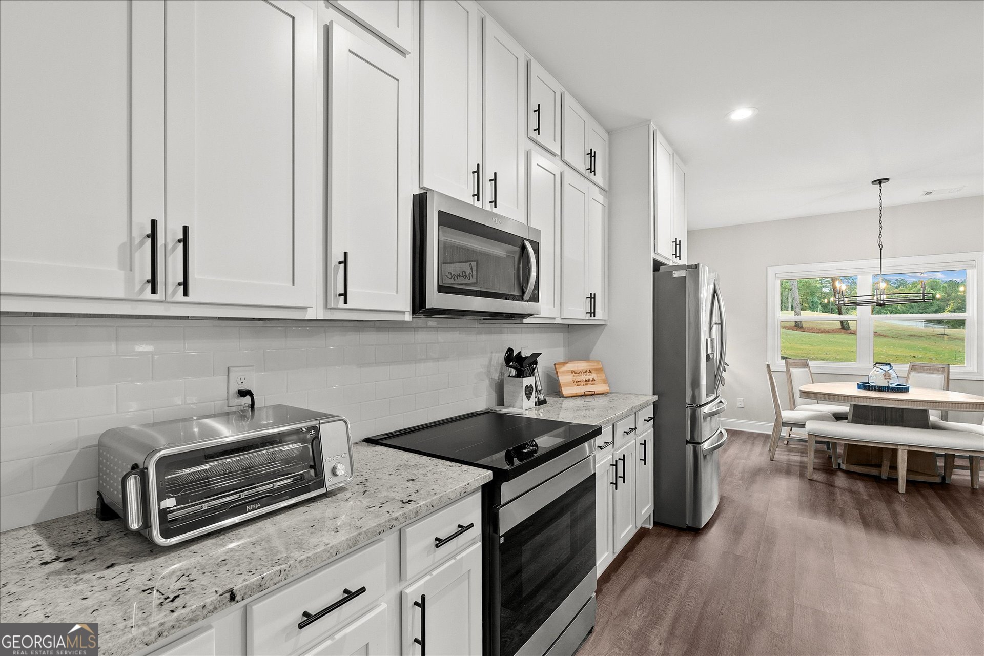 3260 Greenhill Court Villa Rica, GA 30180 - Photo 23 of 80 a kitchen with stainless steel appliances a stove a sink dishwasher a microwave oven with white cabinets and wooden floor