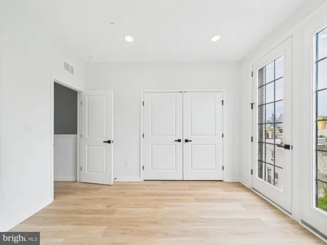 a view of an empty room with closet and a window