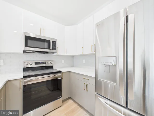 a kitchen with stainless steel appliances white cabinets and a stove top oven