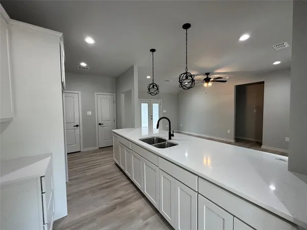 a large kitchen with stainless steel appliances a large counter top and a wooden floors