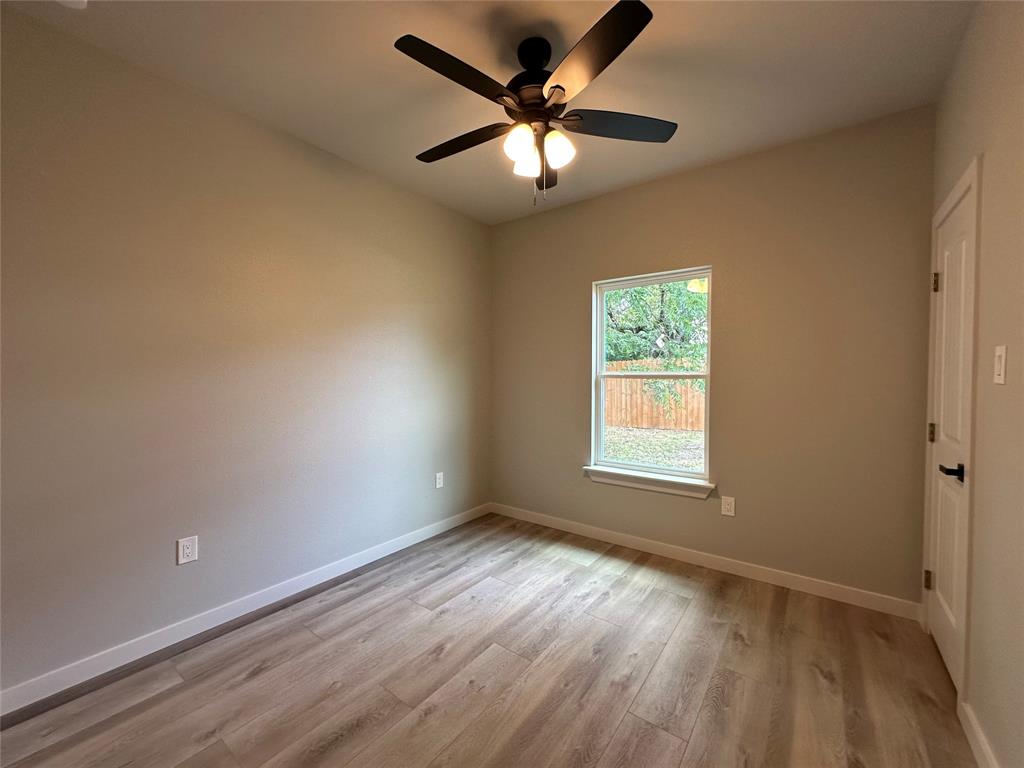 317 North Clark Street Comanche, TX 76442 - Photo 16 of 35 an empty room with window and ceiling fan