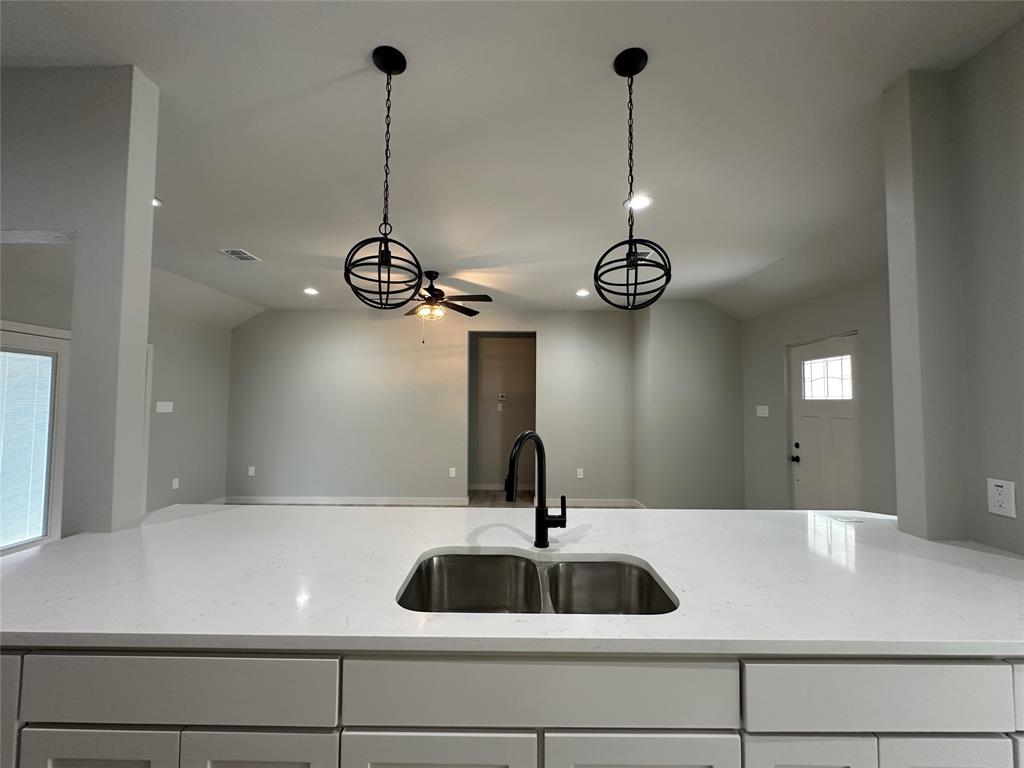 317 North Clark Street Comanche, TX 76442 - Photo 8 of 35 a view of a sink a mirror and a lamp wooden floor