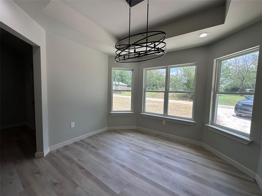 317 North Clark Street Comanche, TX 76442 - Photo 10 of 35 a view of an empty room with wooden floor and chandelier