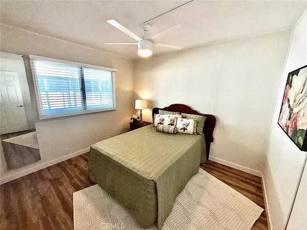 a living room with a bed and a dresser next to a window