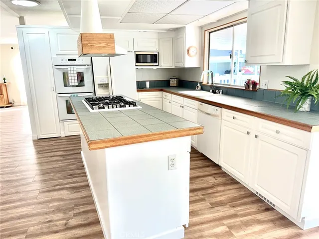 a kitchen with granite countertop a sink a counter top space and cabinets
