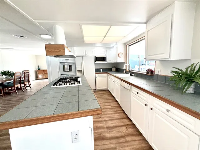 a kitchen with stainless steel appliances kitchen island granite countertop a sink a counter space and cabinets