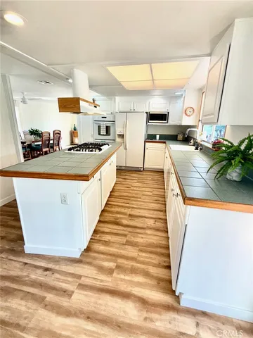 a large kitchen with stainless steel appliances kitchen island granite countertop a large counter top and a view of living room