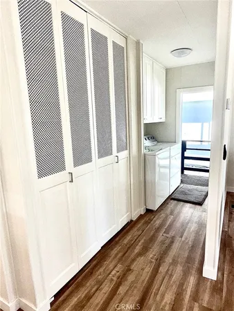 a view of a kitchen with wooden floor and electronic appliances