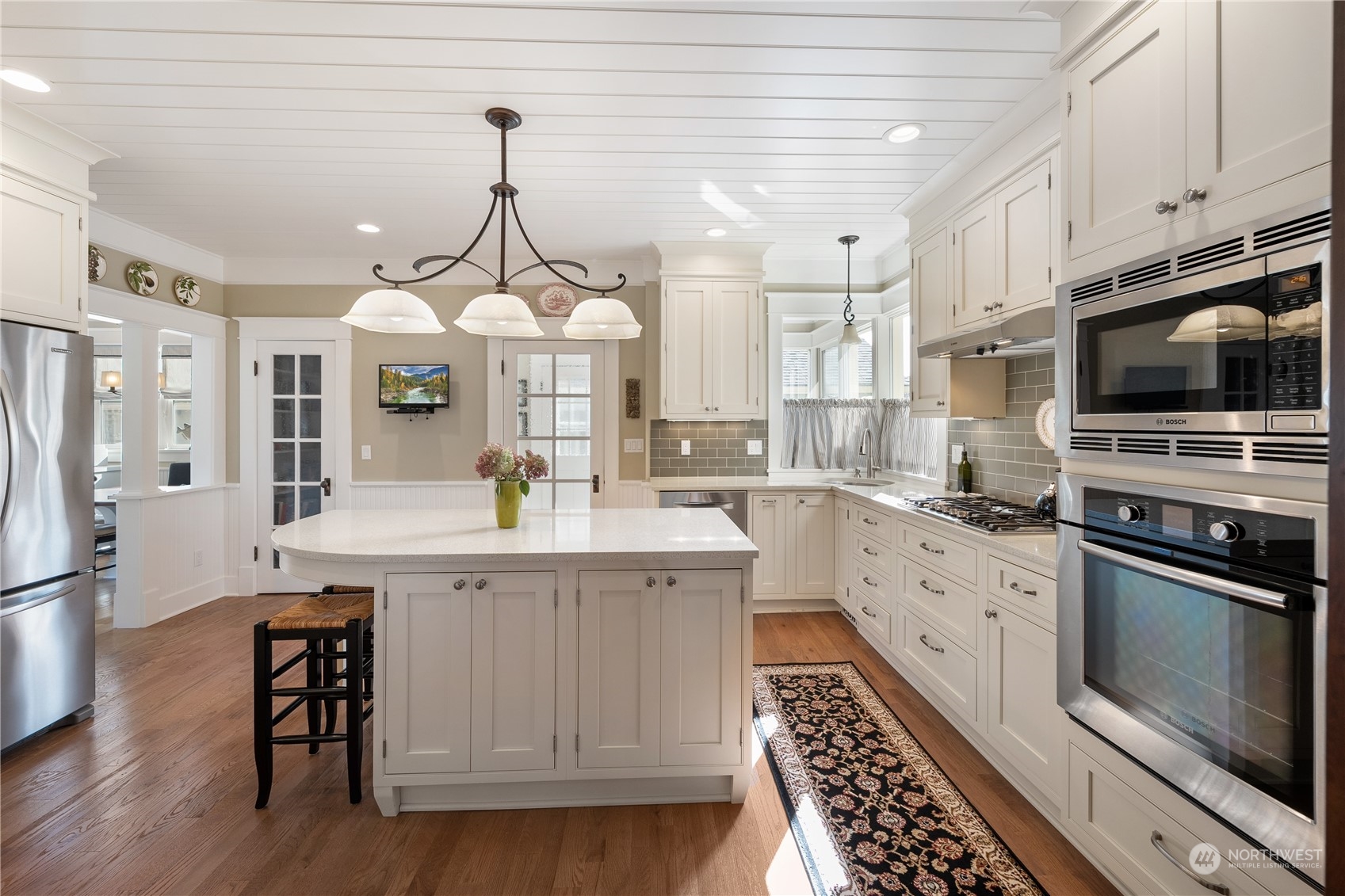 1317 9th Street Anacortes, WA 98221 - Photo 18 of 38 a kitchen with granite countertop a stove a sink dishwasher a refrigerator and a dining table with wooden floor