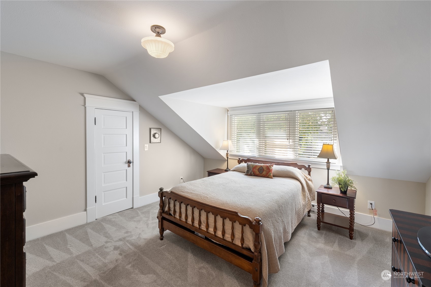 1317 9th Street Anacortes, WA 98221 - Photo 27 of 38 a bedroom with a bed window and a chandelier