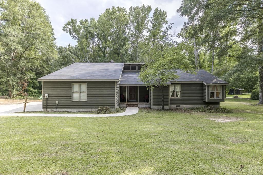 6150 Sandy Point Road Lizella, GA 31052 - Photo 1 of 1 a front view of a house with a garden and trees