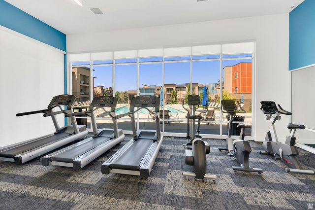 7713 Navarro View Court Midvale, UT 84047 - Photo 38 of 41 Fitness center with a large window overlooking the outdoor swimming pool