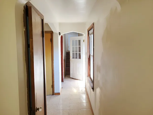 a view of a hallway with wooden shelves