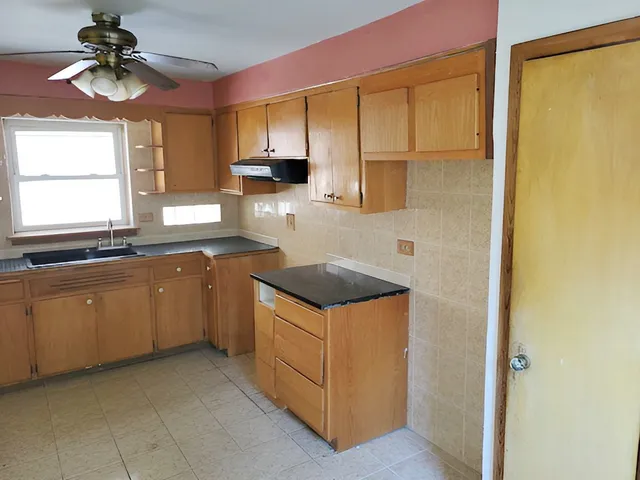 a kitchen with granite countertop a sink a stove and cabinets