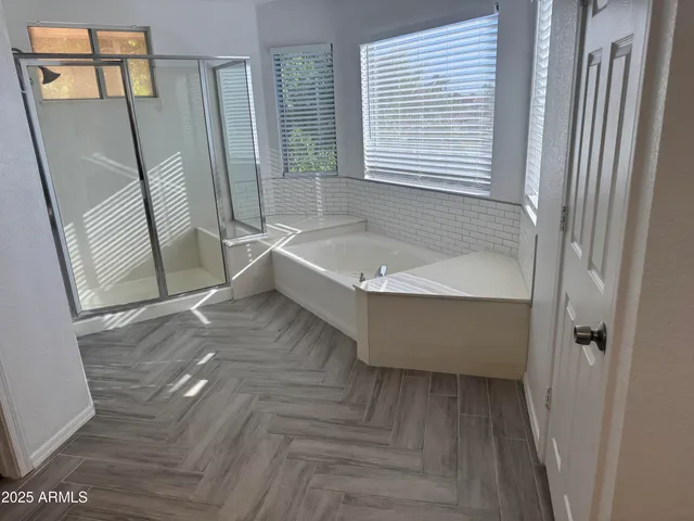 a bathroom with a tub a sink and a shower