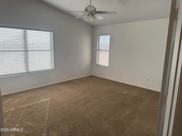 an empty room with a window and a fan