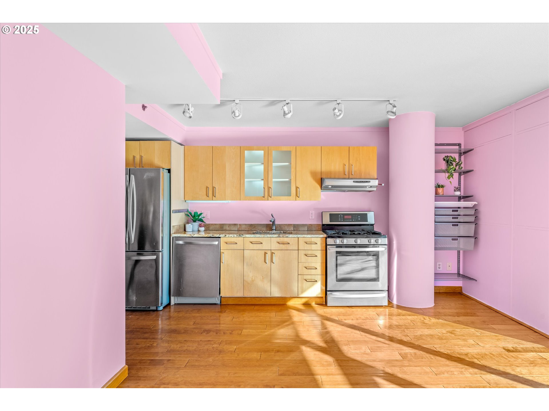 533 Northeast Holladay Street, Unit 605 Portland, OR 97232 - Photo 12 of 42 a kitchen with stainless steel appliances kitchen island granite countertop a refrigerator and a stove top oven