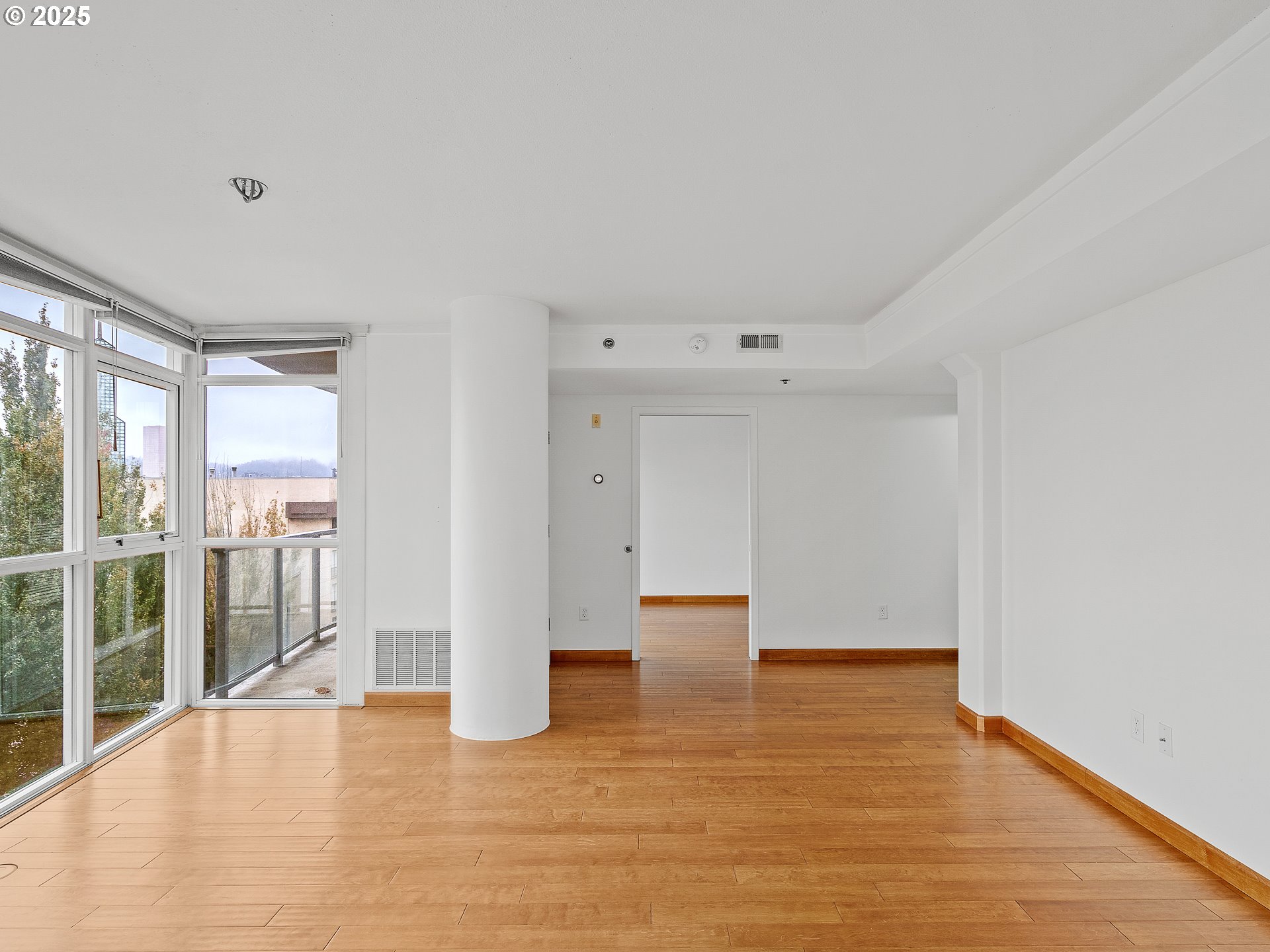 533 Northeast Holladay Street, Unit 605 Portland, OR 97232 - Photo 21 of 42 a view of an empty room with wooden floor and a window