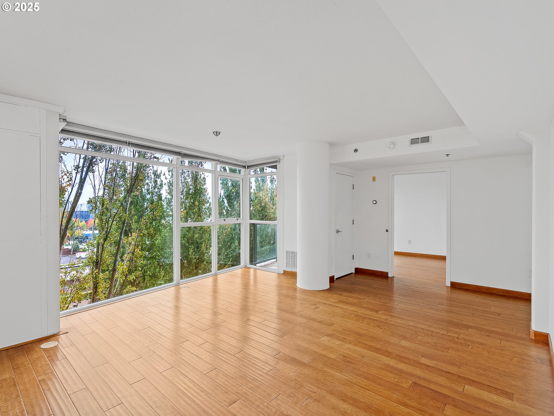 533 Northeast Holladay Street, Unit 605 Portland, OR 97232 - Photo 22 of 42 a view of an empty room with wooden floor and a window