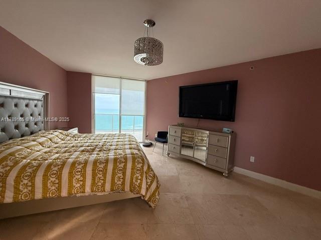 18911 Collins Avenue, Unit 2804 Sunny Isles Beach, FL 33160 - Photo 12 of 38 a spacious bedroom with a bed and a flat screen tv
