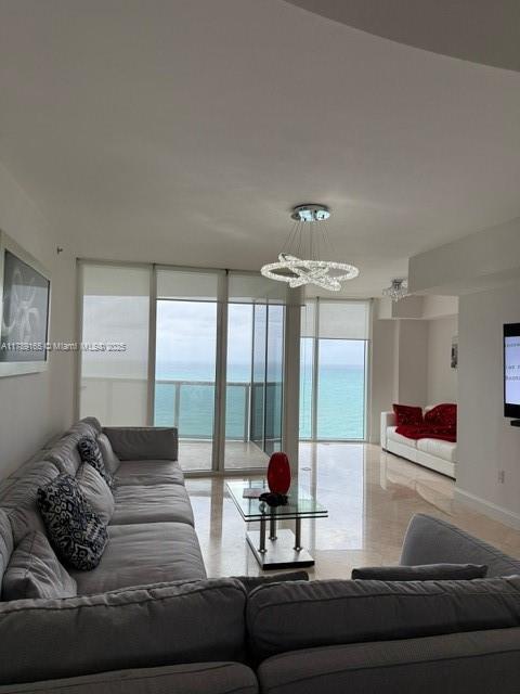 18911 Collins Avenue, Unit 2804 Sunny Isles Beach, FL 33160 - Photo 19 of 38 a living room with furniture and large windows