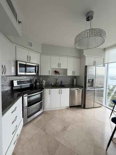 18911 Collins Avenue, Unit 2804 Sunny Isles Beach, FL 33160 - Photo 22 of 38 a kitchen with stainless steel appliances a refrigerator sink and cabinets