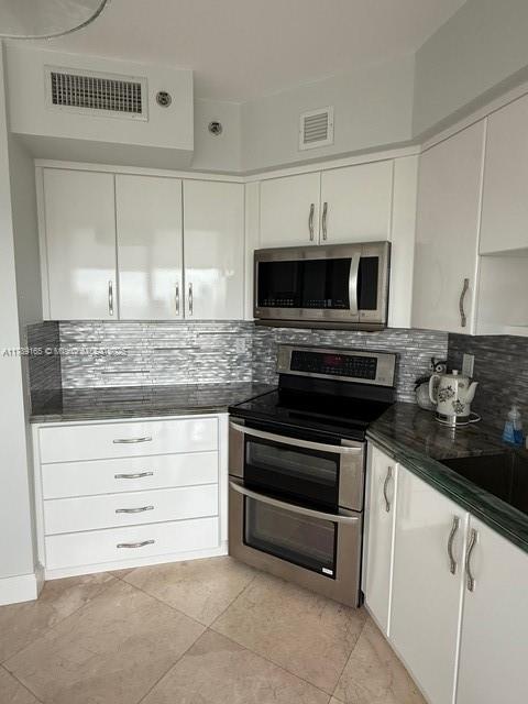 18911 Collins Avenue, Unit 2804 Sunny Isles Beach, FL 33160 - Photo 27 of 38 a kitchen with granite countertop white cabinets and stainless steel appliances