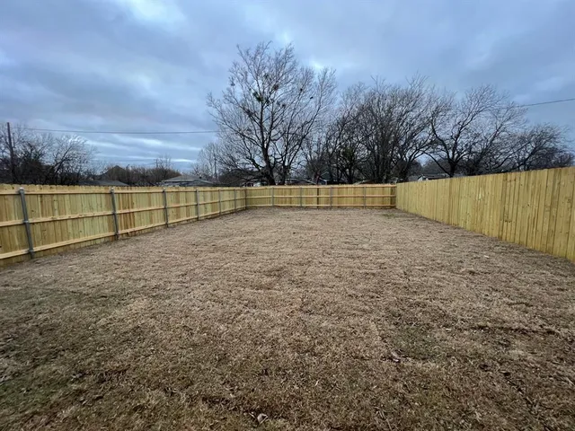 a view of yard with wooden fence