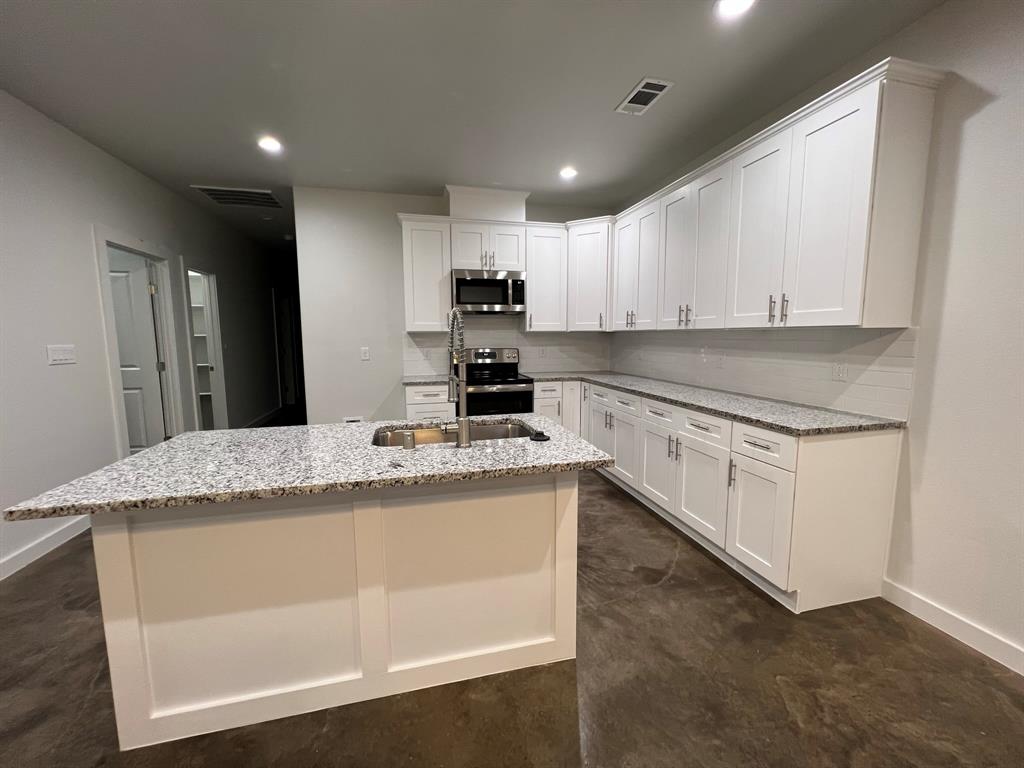 402 North Elliott Avenue Sherman, TX 75090 - Photo 3 of 19 a kitchen with granite countertop white cabinets and white appliances
