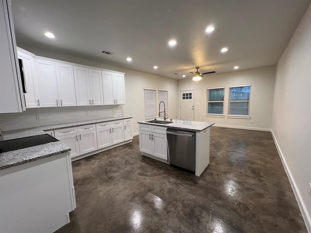 402 North Elliott Avenue Sherman, TX 75090 - Photo 4 of 19 a large kitchen with stainless steel appliances granite countertop a stove a sink a refrigerator and white cabinets with wooden floor