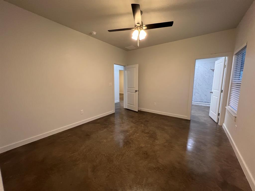 402 North Elliott Avenue Sherman, TX 75090 - Photo 7 of 19 an empty room with a chandelier fan and windows