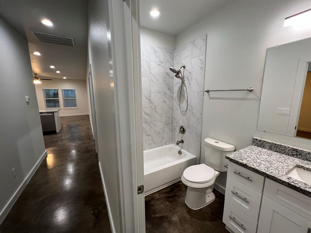 402 North Elliott Avenue Sherman, TX 75090 - Photo 10 of 19 a bathroom with a granite countertop sink a toilet and shower