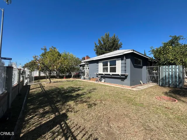 a view of a house with backyard and trees
