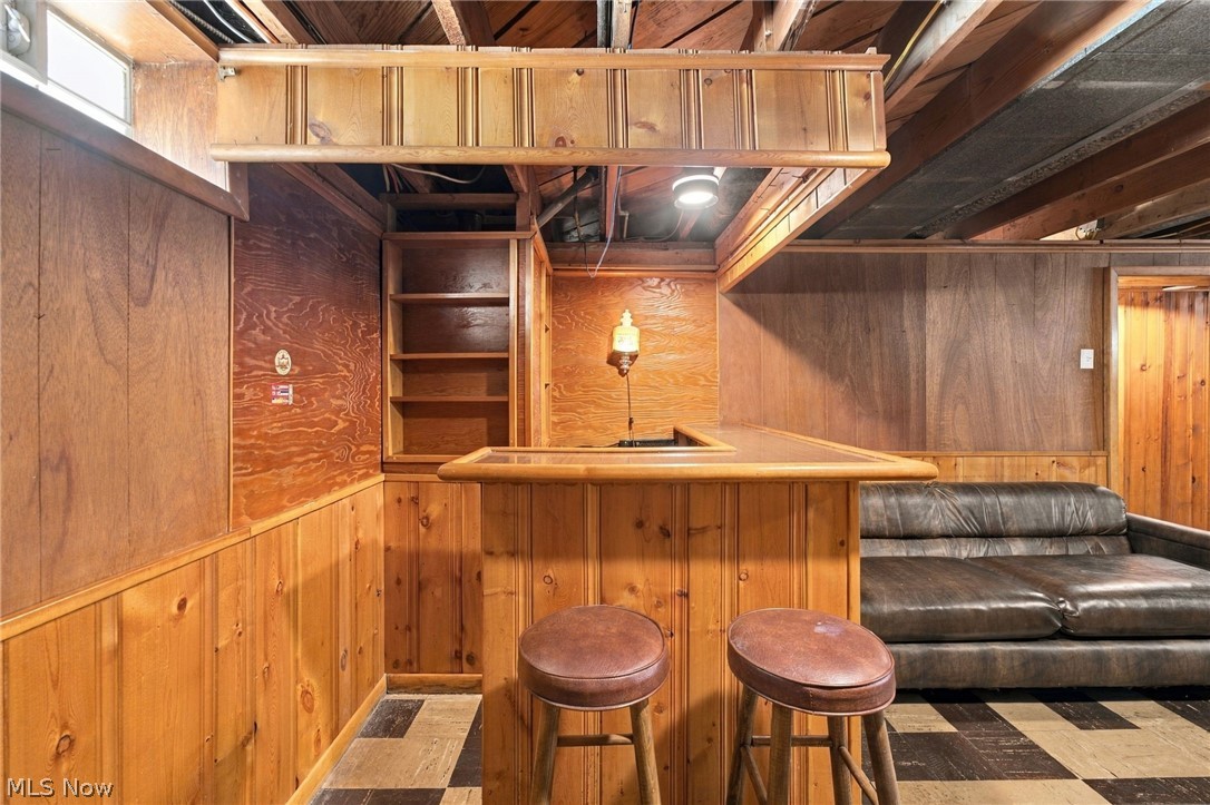 1434 Sunset Road Mayfield Heights, OH 44124 - Photo 32 of 36 Wood-paneled room featuring a built-in bar with wood paneling and a dedicated built-in shelving unit