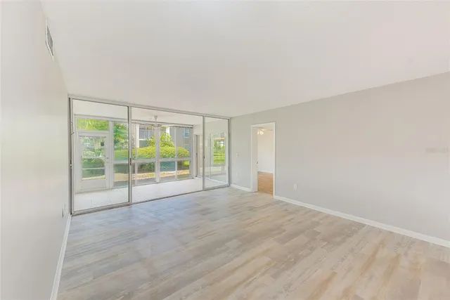 a view of an empty room and window ceiling fan