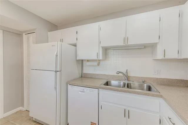 a kitchen with a white stove refrigerator and cabinets