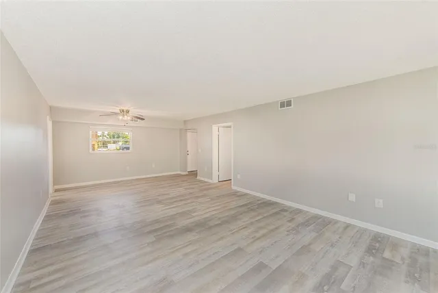 a view of empty room with wooden floor