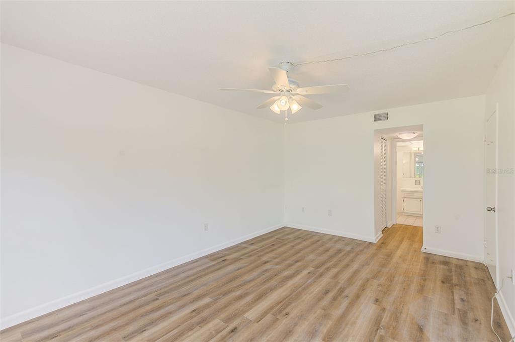 10280 Imperial Point Drive West, Unit 7 Largo, FL 33774 - Photo 34 of 51 an empty room with wooden floor and fan
