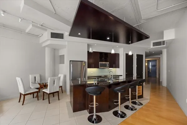 a kitchen with refrigerator and chairs