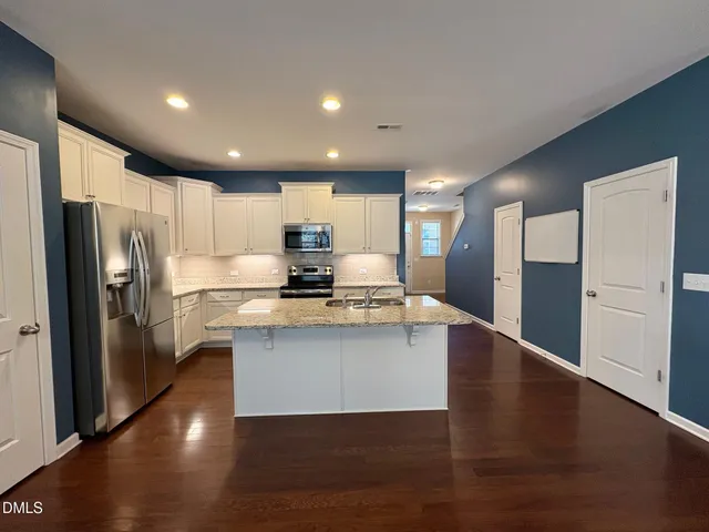 a kitchen with stainless steel appliances a refrigerator and a stove top oven