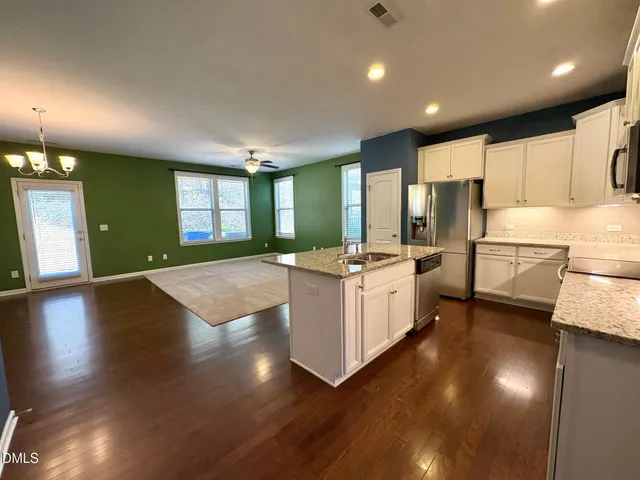 a large white kitchen with lots of counter space a sink and appliances