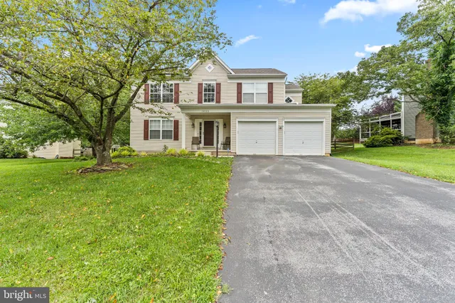 a front view of a house with a yard and trees