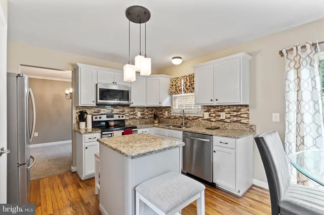 a kitchen with stainless steel appliances granite countertop a stove oven and a refrigerator