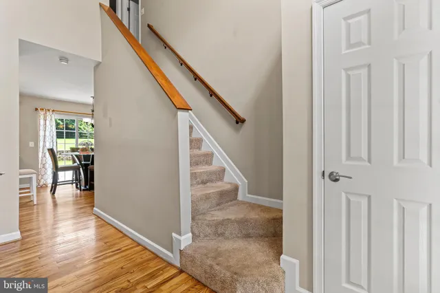 a kitchen with stainless steel appliances granite countertop a sink dishwasher a stove and a dining table with wooden floor