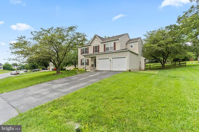 a view of a house with a big yard and large trees