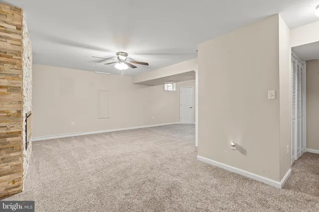 en empty room with windows and fireplace